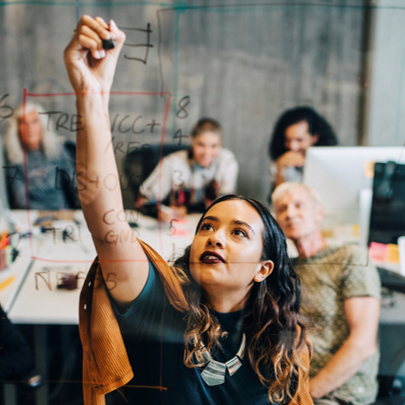 Frau schreibt Formeln auf ein transparentes Whiteboard